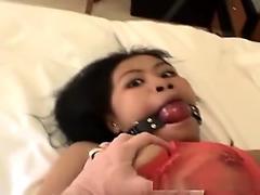 Adorable Asian babe tied up on a bed